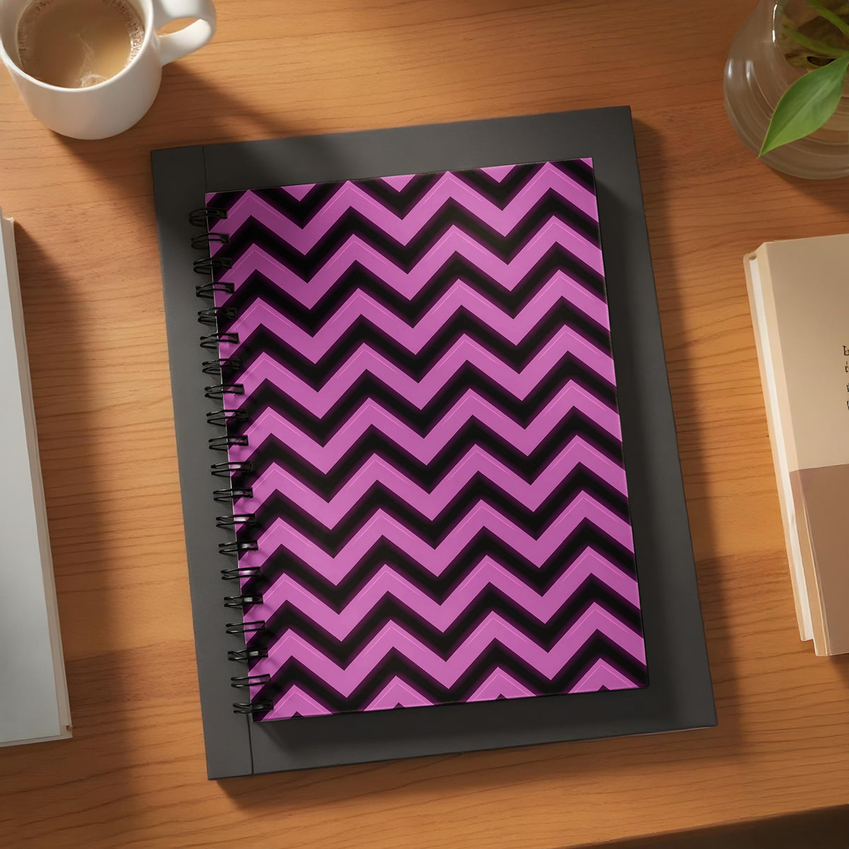 Spiral notebook with purple and black chevron pattern on a wooden desk.