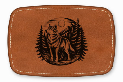 Brown leather patch with white stitching and a laser-engraved forest wolf scene.