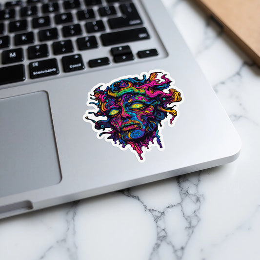 Psychedelic face sticker on a laptop keyboard and surface.