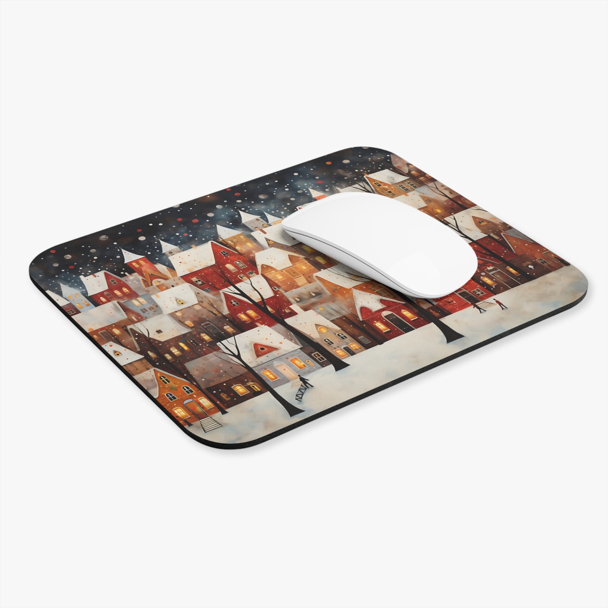 Mousepad with a snowy village scene and a white computer mouse.