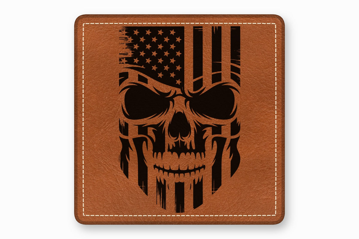 Square brown leather patch with white stitched border and engraved black American flag skull graphic.