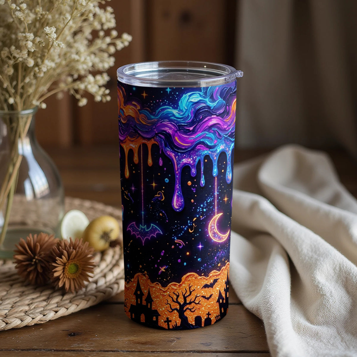 Tumbler with Halloween night design featuring dripping galaxy, bats, crescent moon, and haunted houses.