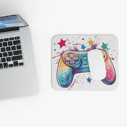 Colorful video game controller and stars on a white mousepad next to a laptop.