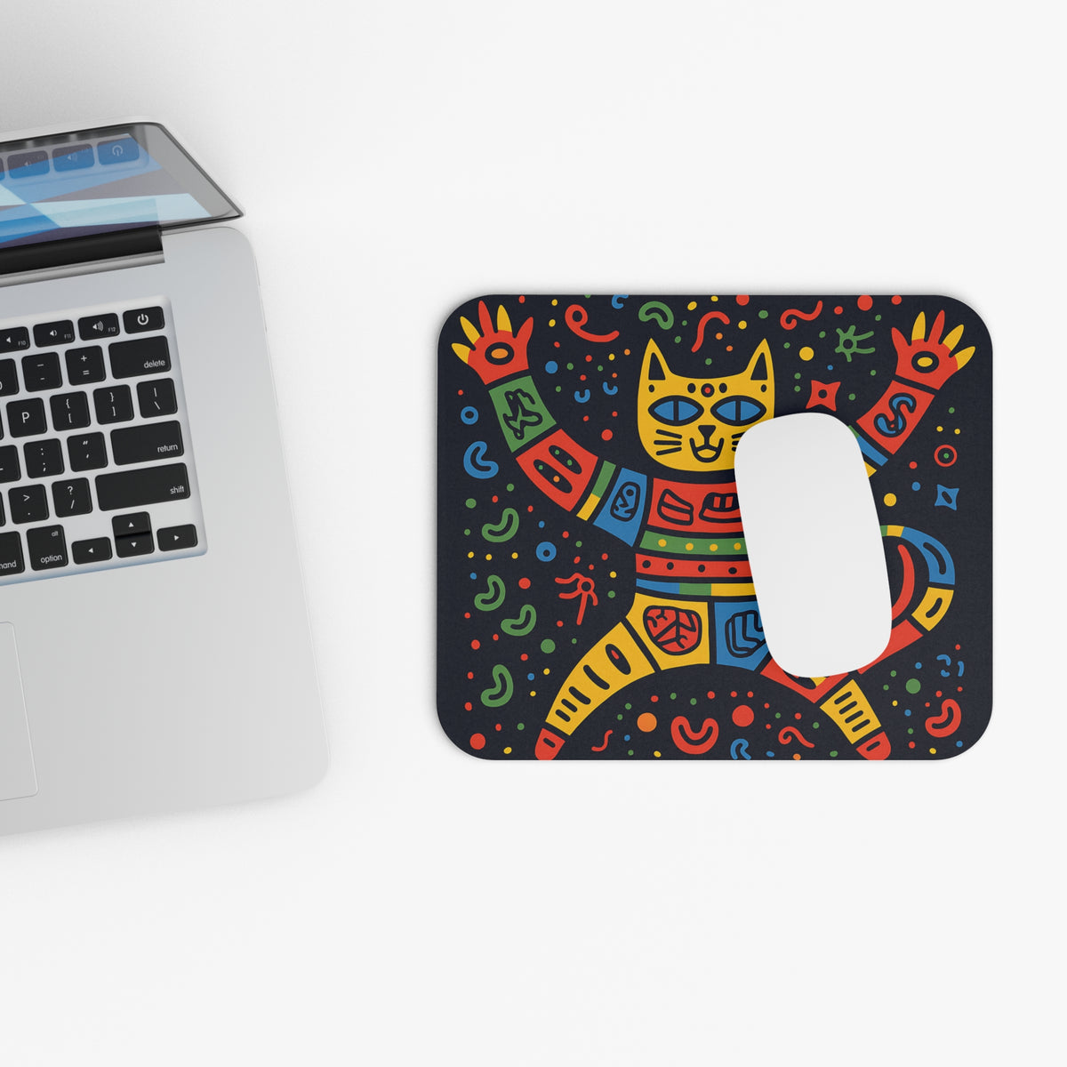 Mousepad with a colorful geometric cat illustration and a white computer mouse.