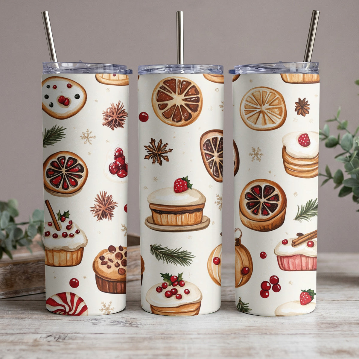 Three tumblers with a pattern of Christmas treats like cookies, cupcakes, and dried oranges.