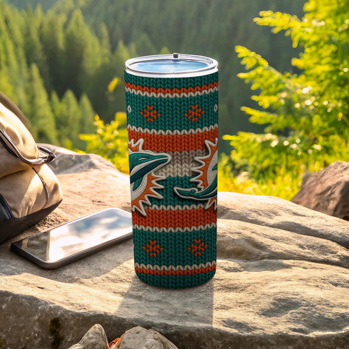 Tumbler with teal, orange, and white knit pattern and dolphin graphics.
