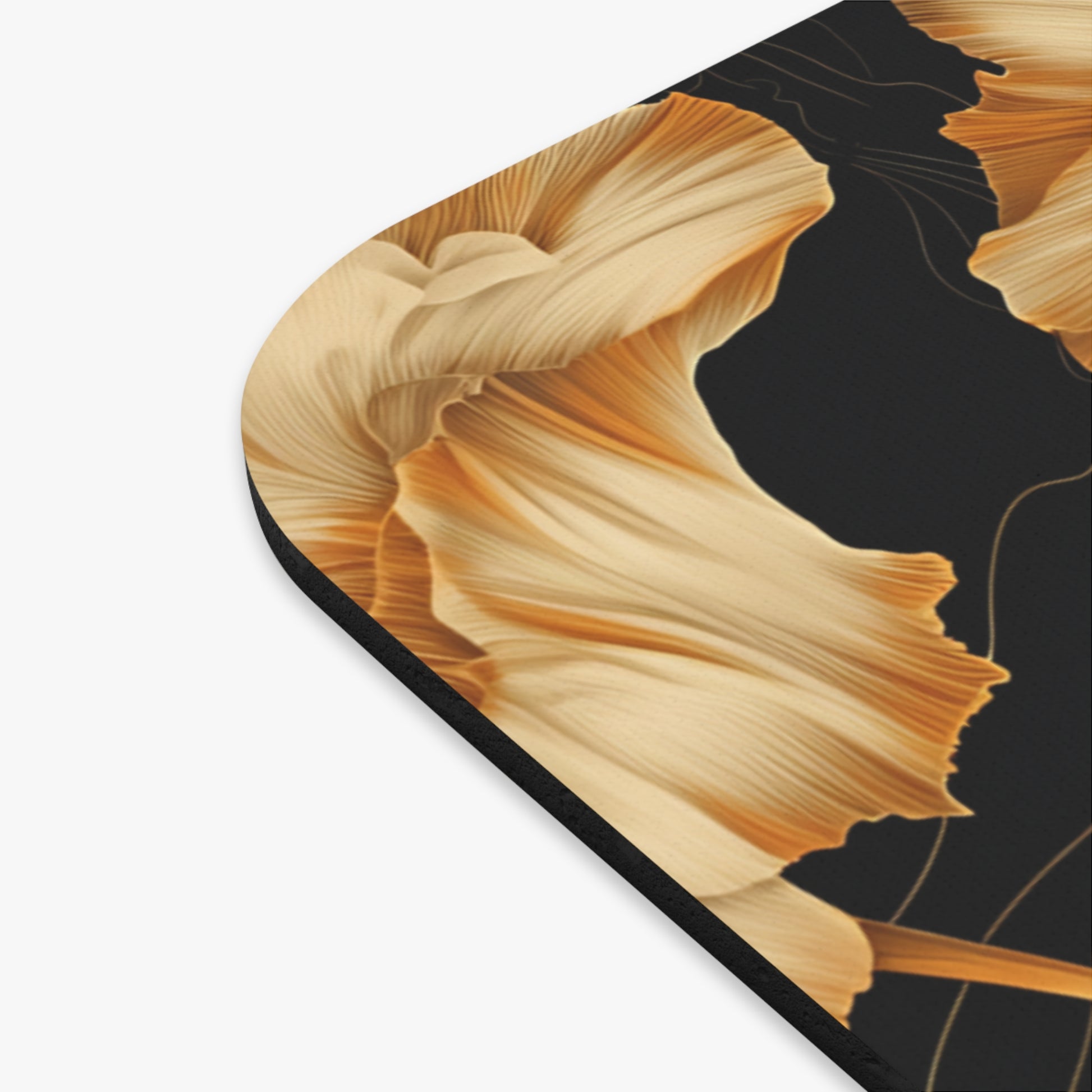 Close-up of a black mousepad with a golden floral abstract design.