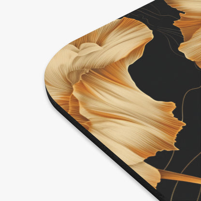 Close-up of a black mousepad with a golden floral abstract design.