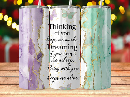 Three tumblers with marble designs and butterflies, featuring text about love.