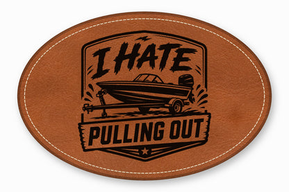 Oval brown leather patch with white stitching featuring a black boat illustration and the text I HATE PULLING OUT.