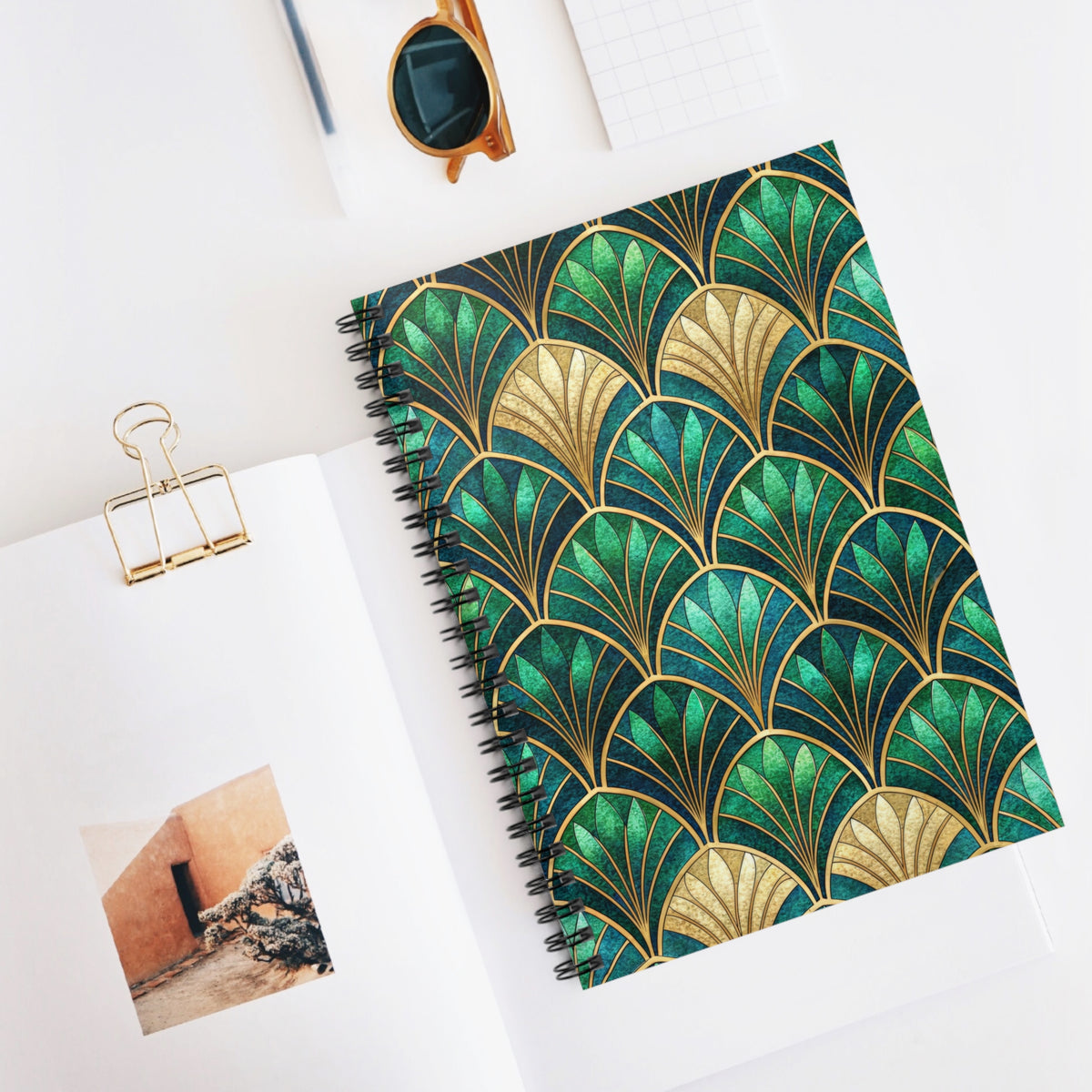 Spiral notebook with gold and green art deco fan pattern cover.