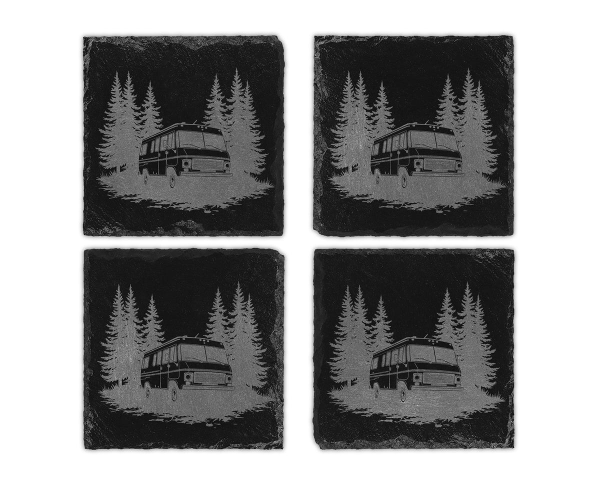Four square black slate coasters featuring an engraved design of a camper van parked among pine trees.