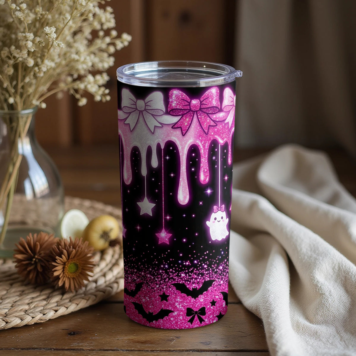 Tumbler with pink glitter drips, bows, stars, bats, and a cute ghost.