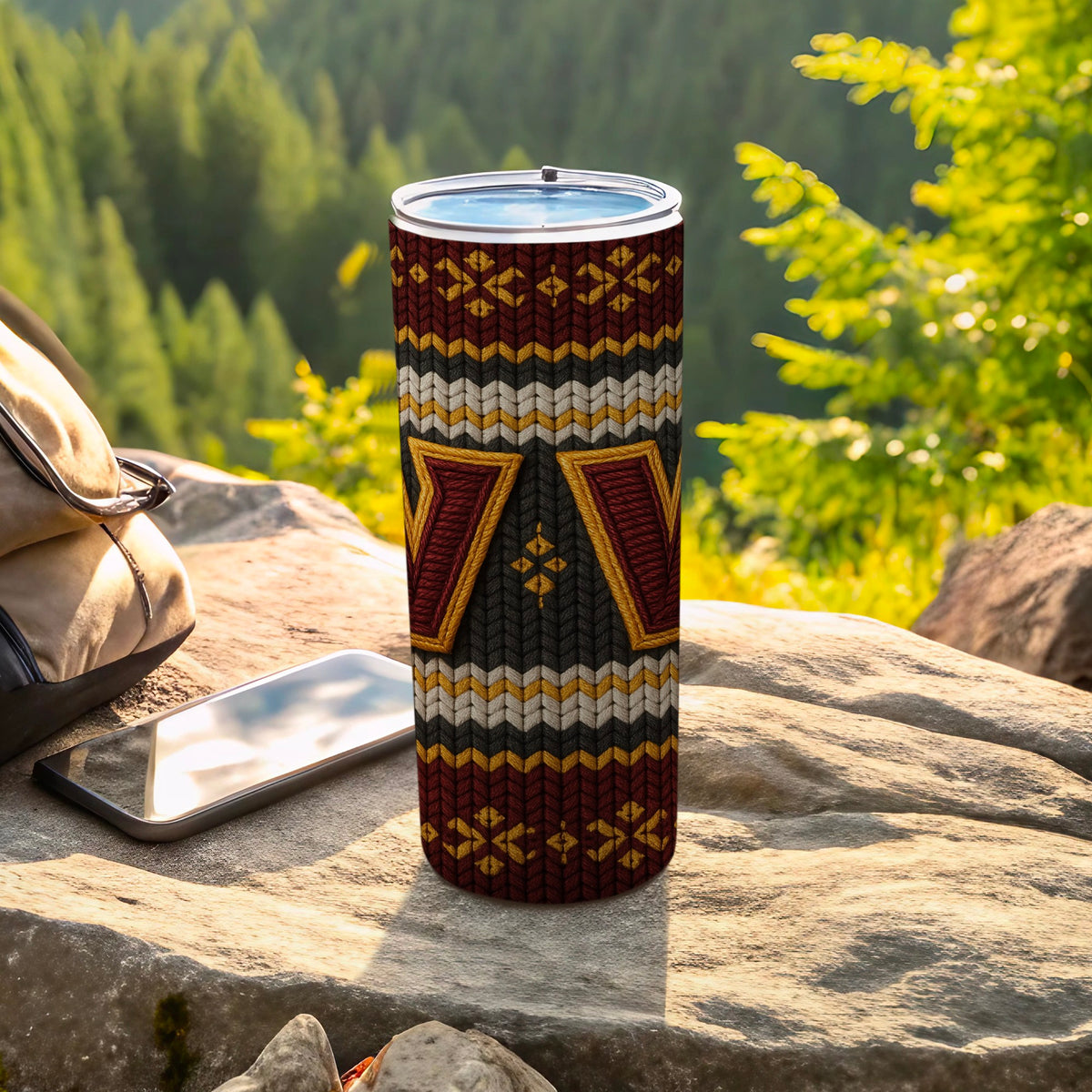 Tumbler with a knitted pattern of maroon, gold, grey, and white chevron and geometric designs.
