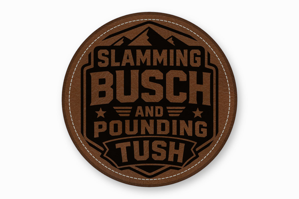 Round brown leather patch featuring mountains and text that reads Slamming Busch and Pounding Tush.