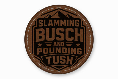 Round brown leather patch featuring mountains and text that reads Slamming Busch and Pounding Tush.