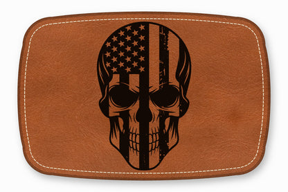 Brown leather patch with rounded corners, white border stitching, and a black skull and American flag graphic.