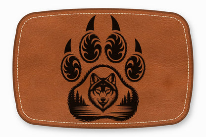 Brown rectangular leather patch with rounded corners, white stitching, and a black wolf and bear paw design.
