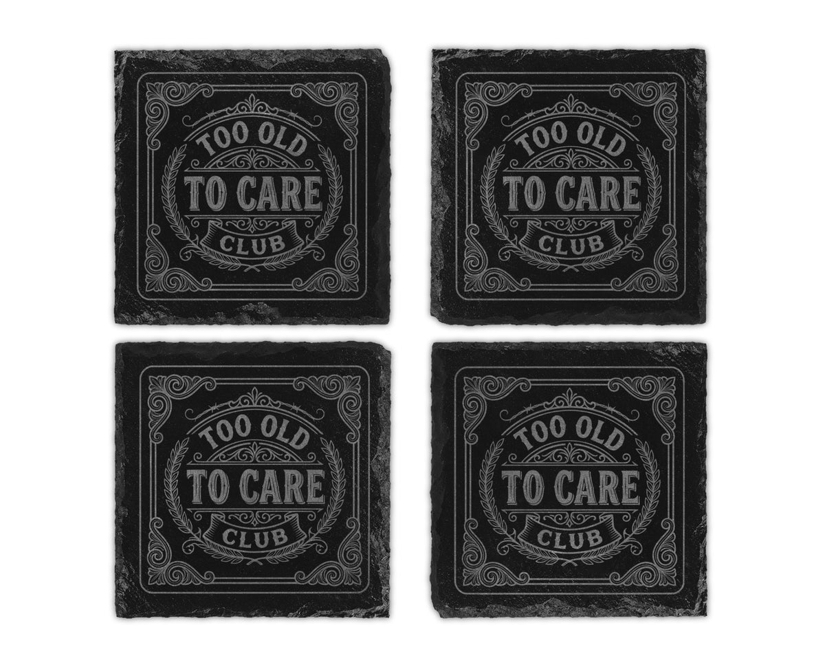 Four slate coasters engraved with "TOO OLD TO CARE CLUB" in a decorative design.