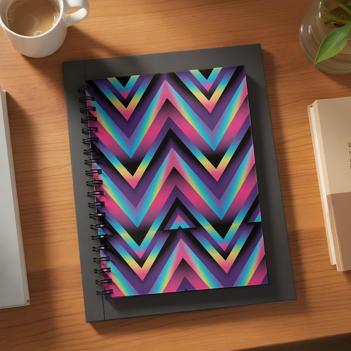 Spiral notebook with colorful chevron pattern on desk with coffee and books