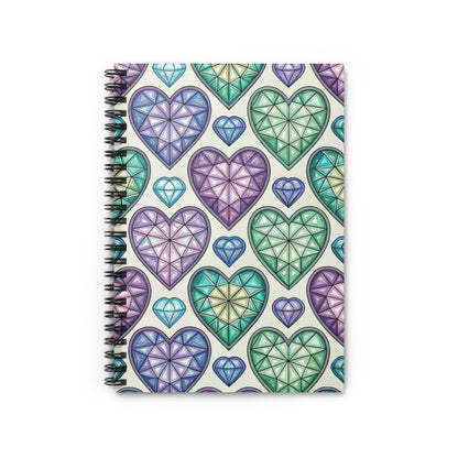 Spiral bound notebook with a pattern of faceted heart-shaped gemstones in purple, blue, and green.
