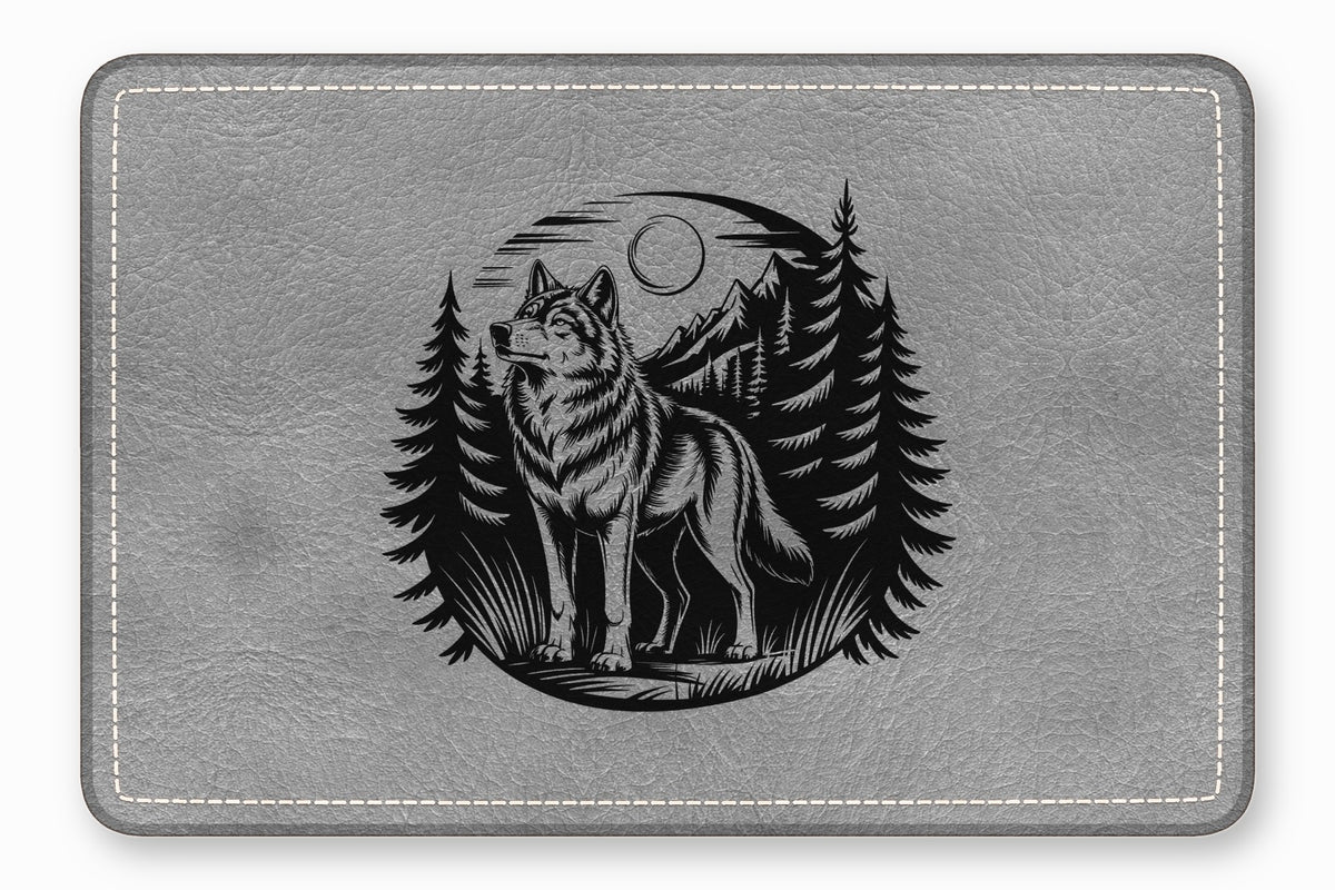 A gray leather pad featuring an embossed black design of a wolf in a forest.