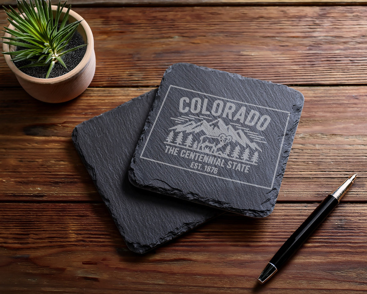 Two slate coasters engraved with "Colorado The Centennial State Est. 1876".
