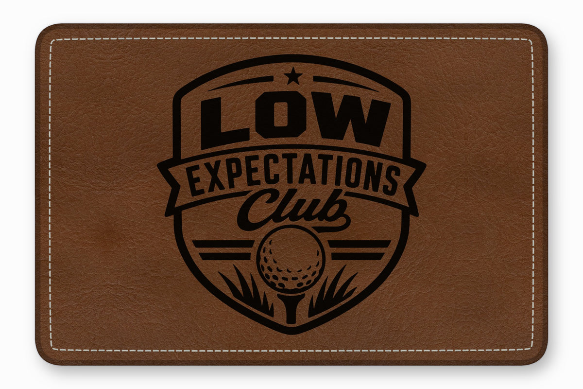 Brown leather rectangular patch with white stitched borders and a black engraved golf emblem.