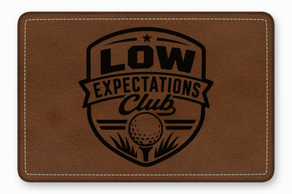 Brown leather rectangular patch with white stitched borders and a black engraved golf emblem.