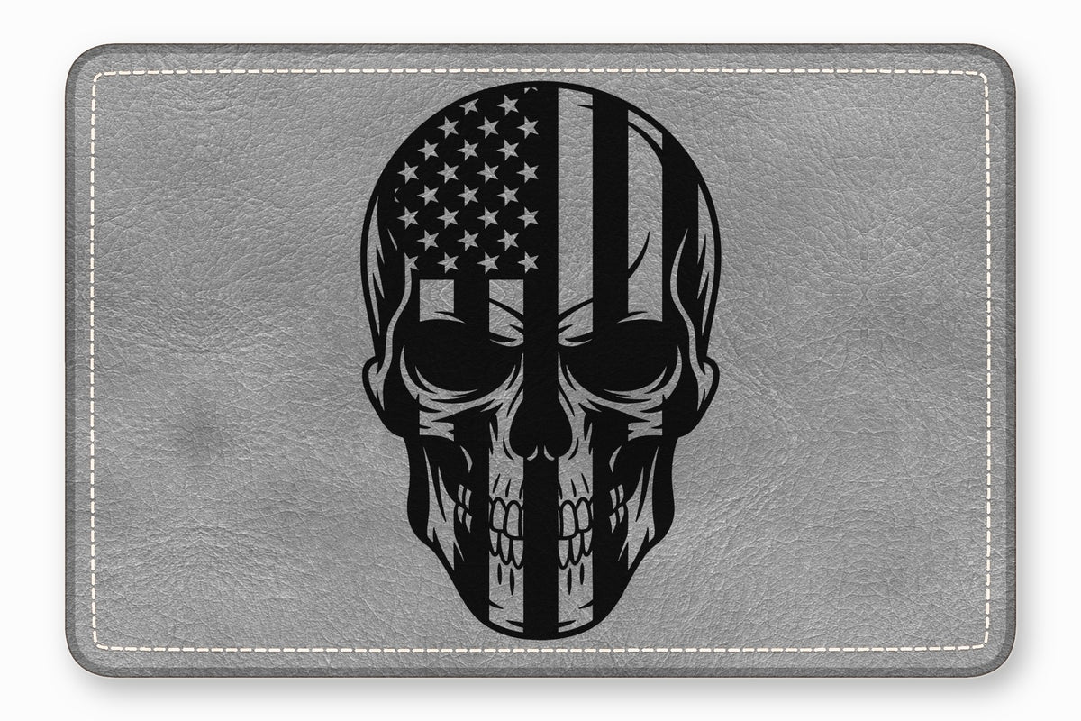 Gray leather rectangular patch with white stitched border and a black skull and American flag graphic.