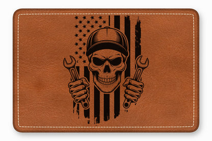 Brown leather patch featuring a black engraved mechanic skull wearing a cap and holding wrenches against an American flag.