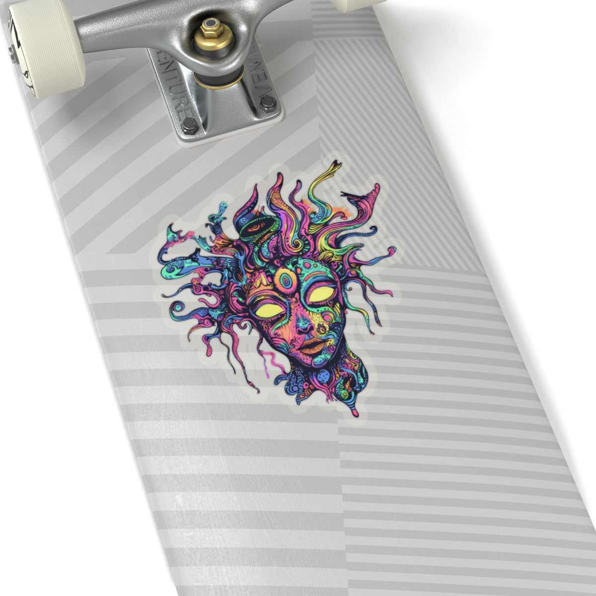 Colorful abstract face sticker with snake-like hair on a skateboard deck.