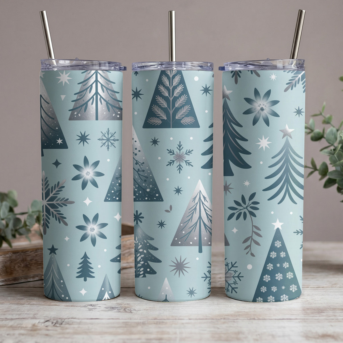 Three tumblers with a blue background and a repeating pattern of Christmas trees and snowflakes.