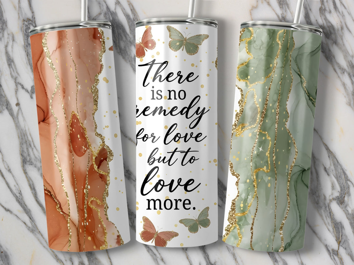 Three tumblers with marble and glitter designs, one with text and butterflies.