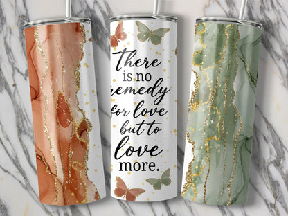 Three tumblers with marble and glitter designs, one with text and butterflies.