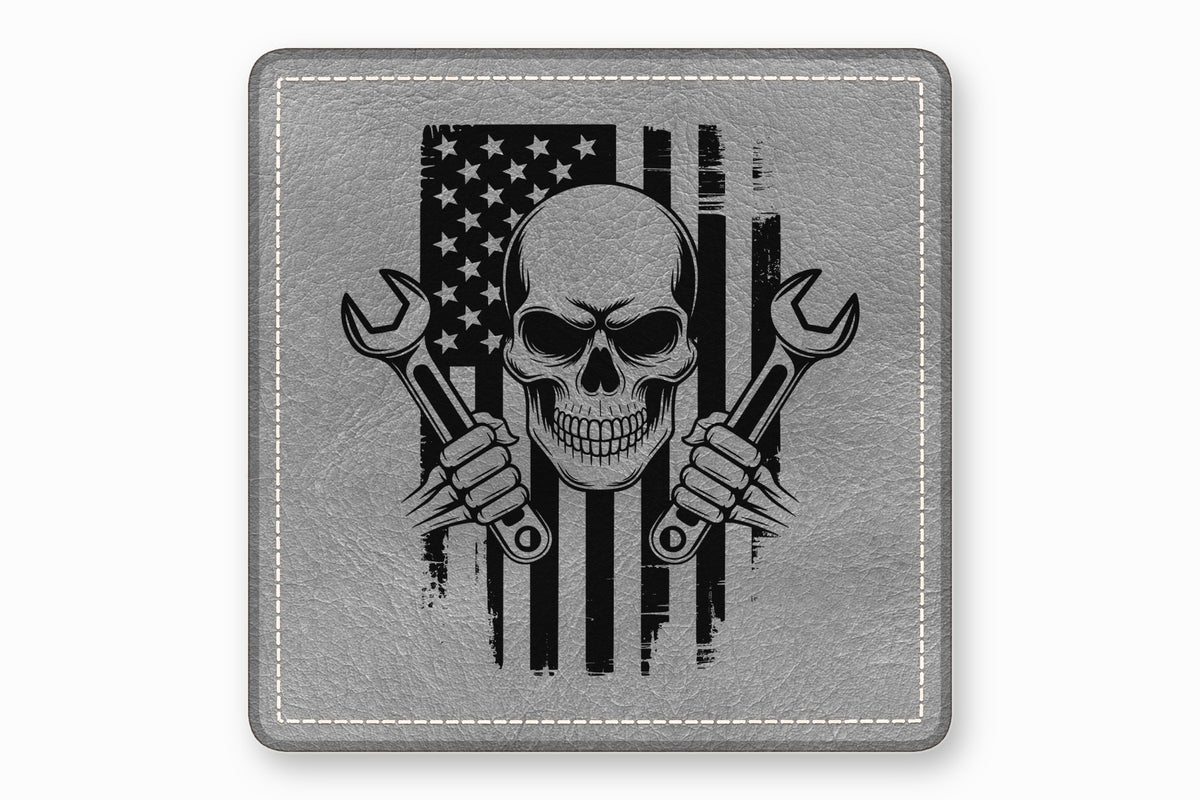 A square gray leather patch featuring a distressed American flag, skull, and crossed wrenches graphic.