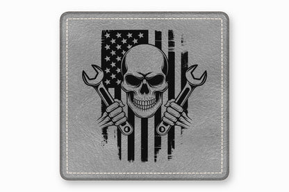 A square gray leather patch featuring a distressed American flag, skull, and crossed wrenches graphic.