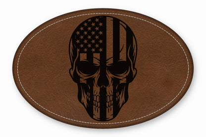 Oval brown leather patch with white stitched border featuring a black skull and American flag design.