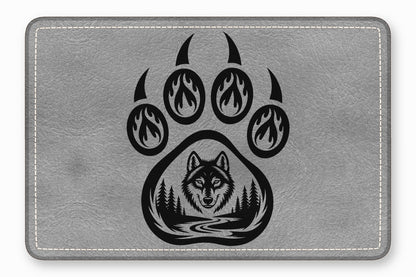Grey leather patch with white stitched border featuring a black bear paw and wolf graphic.