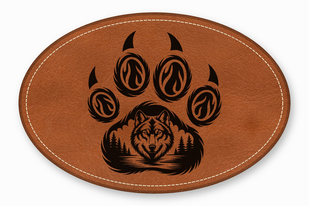 An oval brown leather patch featuring a black laser-engraved wolf face and paw print design.