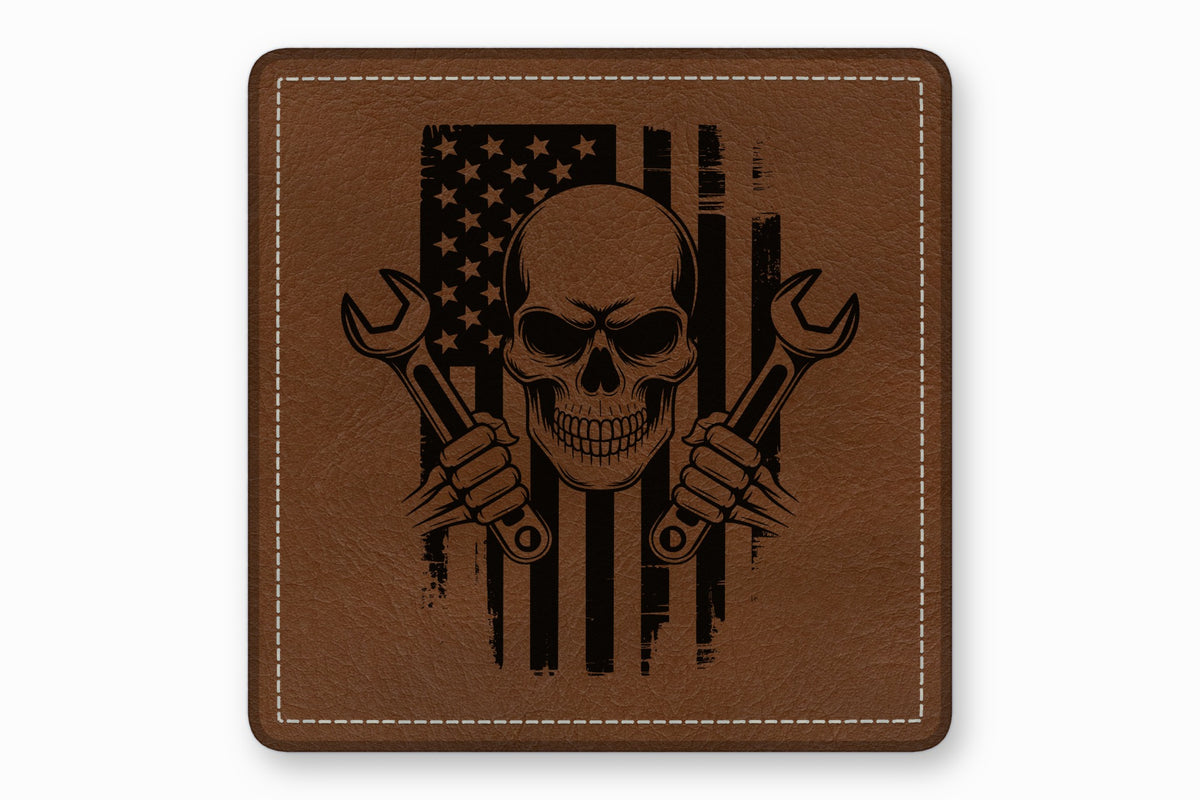 Brown square leather patch with white stitched border and a distressed American flag, skull, and crossed wrenches graphic.