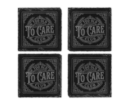 Four slate coasters, each engraved with "Too Old To Care Club".