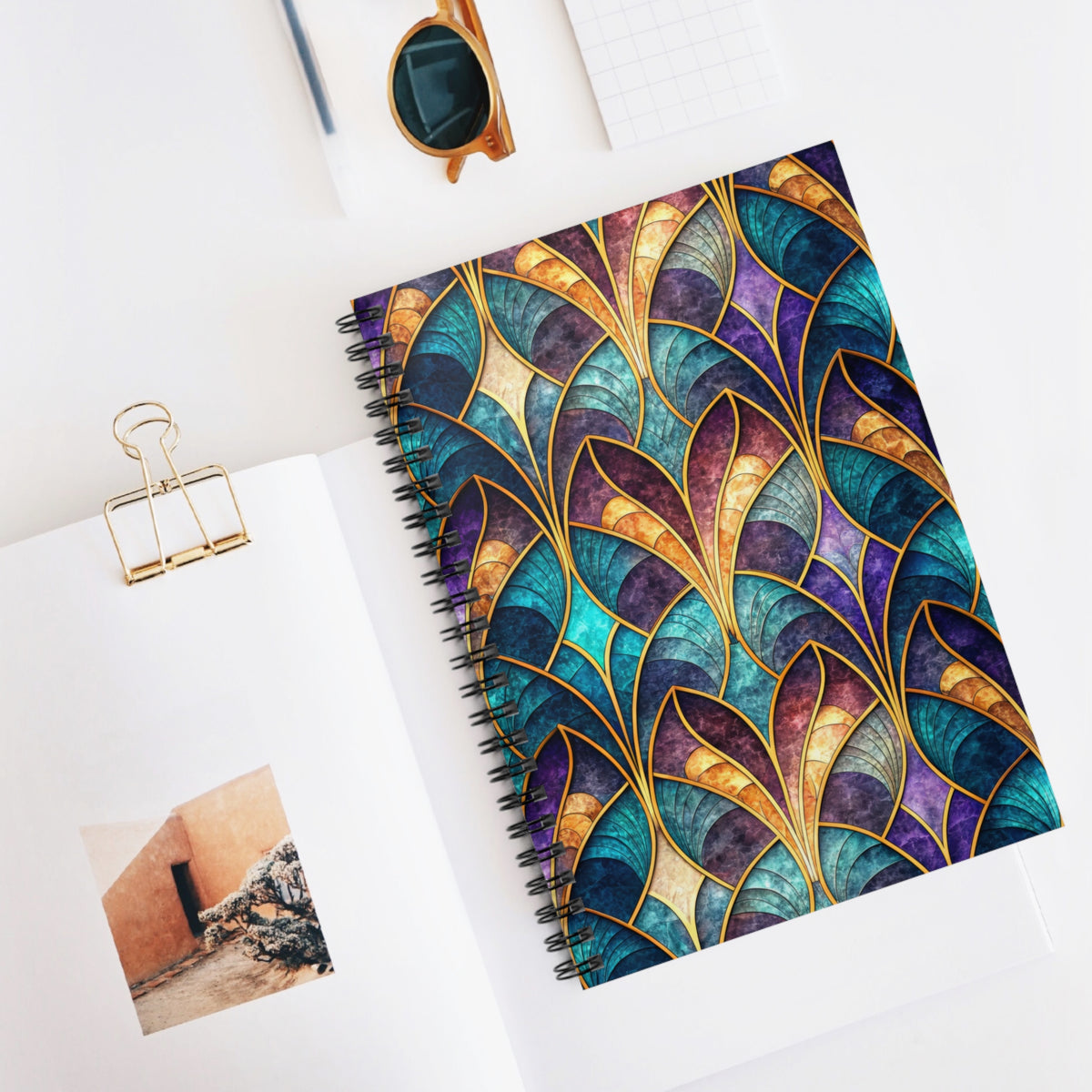 Spiral notebook with abstract stained-glass pattern in teal, purple, and gold.