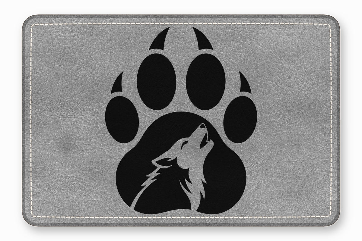 Gray leather patch featuring a black paw print with a howling wolf silhouette inside.
