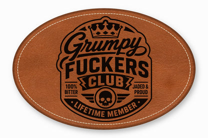 Oval brown leather patch with white stitched border, featuring a black engraved emblem and text.