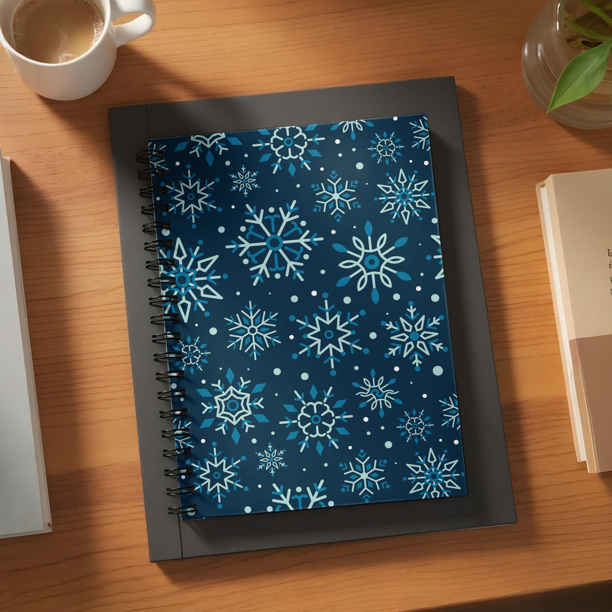 Spiral notebook with a dark blue cover featuring a pattern of light blue and white snowflakes.