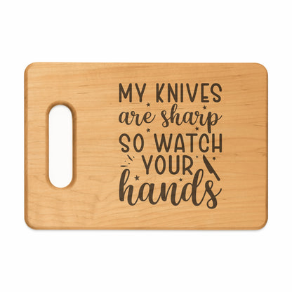 Wooden cutting board with text "My knives are sharp so watch your hands".