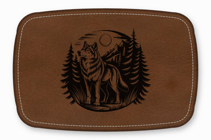 Brown leather patch with white stitched border featuring a laser-engraved wolf standing in a forest.