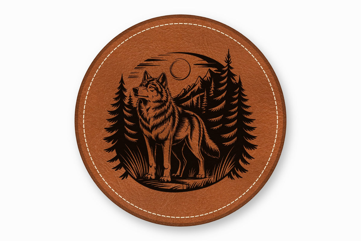 Round brown leather coaster with white stitched border and engraved black wolf forest scene.