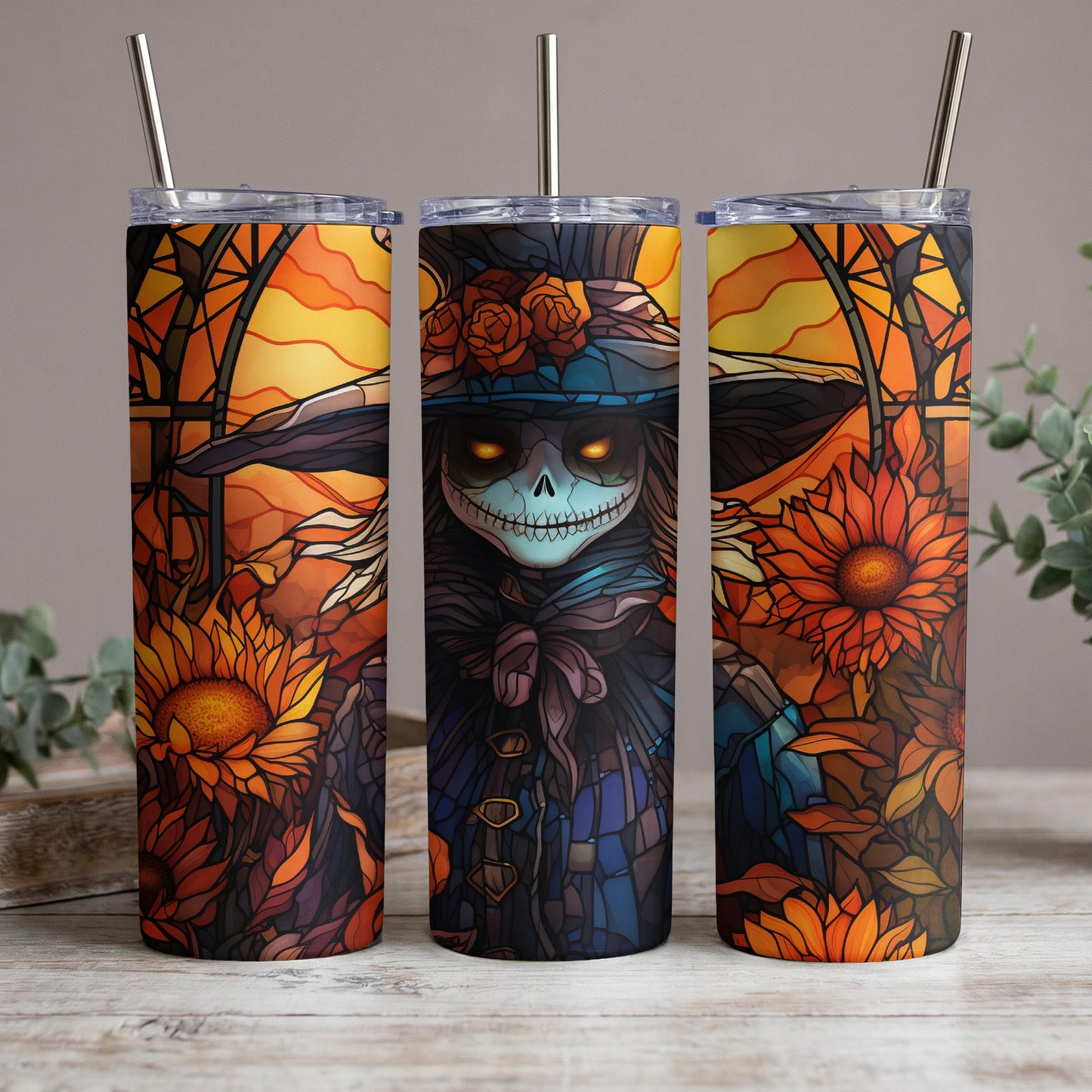 Three tumblers with stained-glass art of a skeleton figure with glowing eyes and sunflowers.